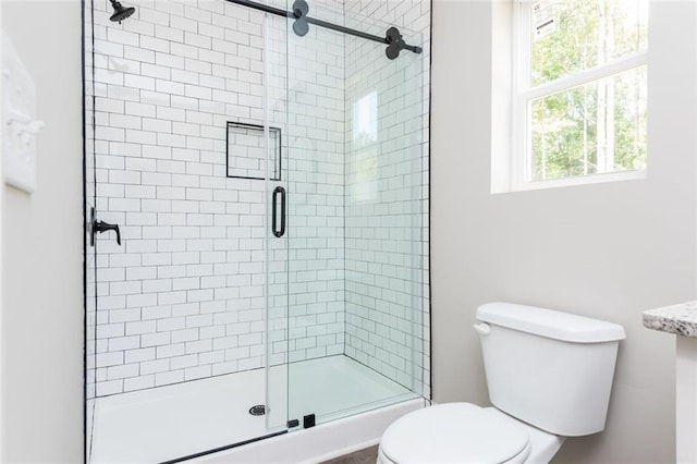 bathroom with a shower stall and toilet