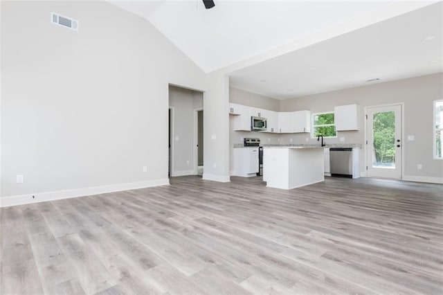 unfurnished living room featuring visible vents, ceiling fan, baseboards, light wood-style floors, and high vaulted ceiling