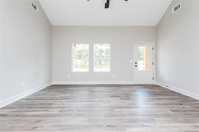 spare room featuring visible vents, baseboards, a ceiling fan, and wood finished floors