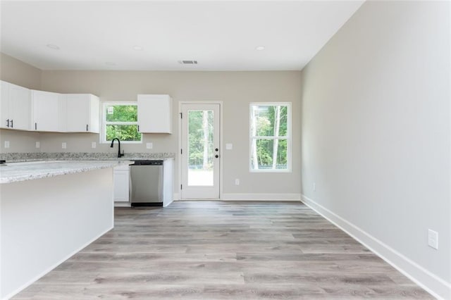 kitchen with light stone counters, baseboards, white cabinetry, dishwasher, and light wood-type flooring