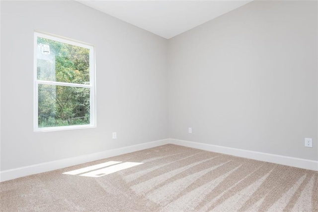 carpeted spare room with a wealth of natural light and baseboards