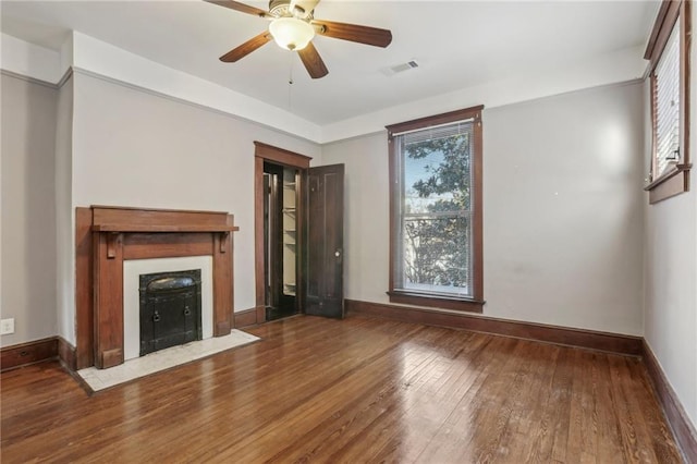 unfurnished living room featuring hardwood / wood-style floors, a wealth of natural light, and ceiling fan