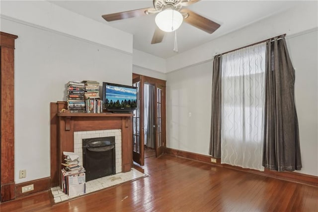 unfurnished living room with a brick fireplace, hardwood / wood-style floors, and ceiling fan