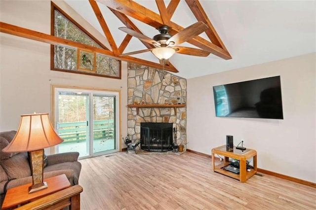 living room featuring ceiling fan, a fireplace, high vaulted ceiling, and light hardwood / wood-style flooring