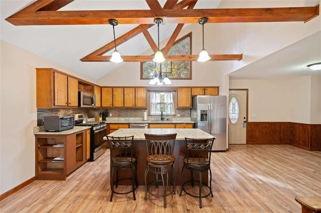 kitchen featuring pendant lighting, backsplash, stainless steel appliances, and high vaulted ceiling