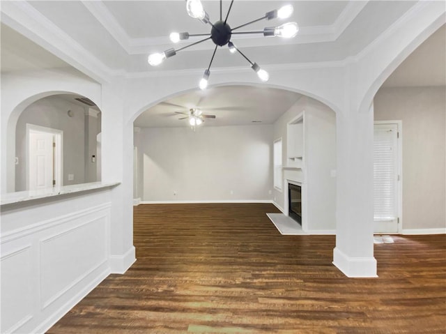 unfurnished living room featuring dark hardwood / wood-style flooring, a raised ceiling, and crown molding