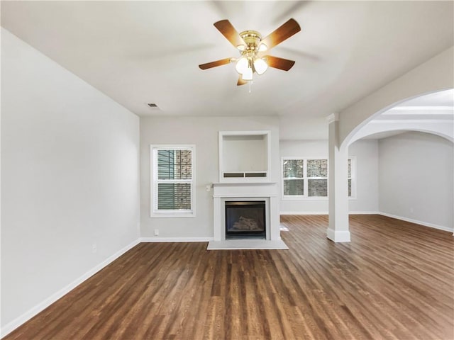 unfurnished living room with ceiling fan and dark wood-type flooring