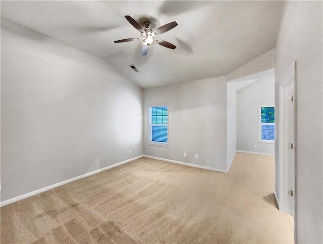 carpeted spare room featuring ceiling fan and vaulted ceiling