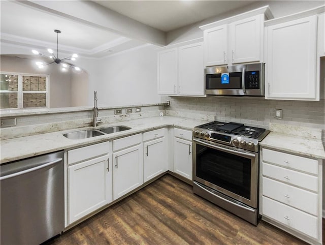 kitchen with sink, white cabinets, pendant lighting, and appliances with stainless steel finishes