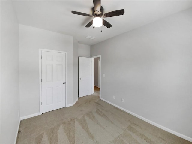 unfurnished bedroom with ceiling fan and light colored carpet