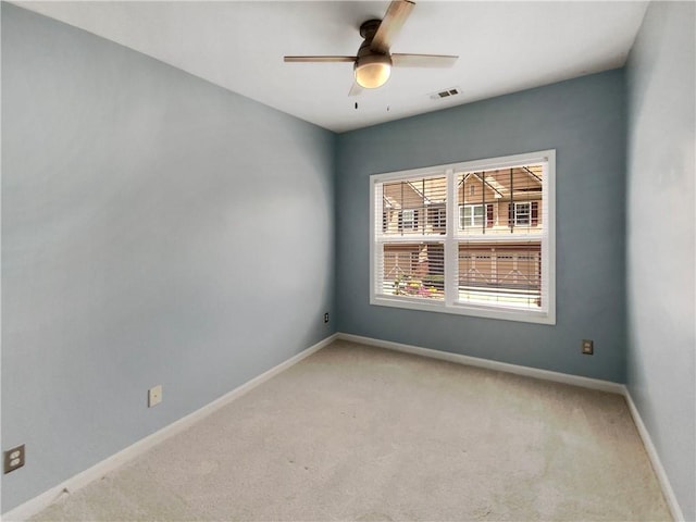 carpeted spare room featuring ceiling fan