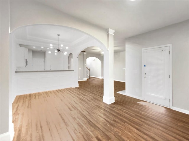 unfurnished living room with a notable chandelier and light hardwood / wood-style flooring