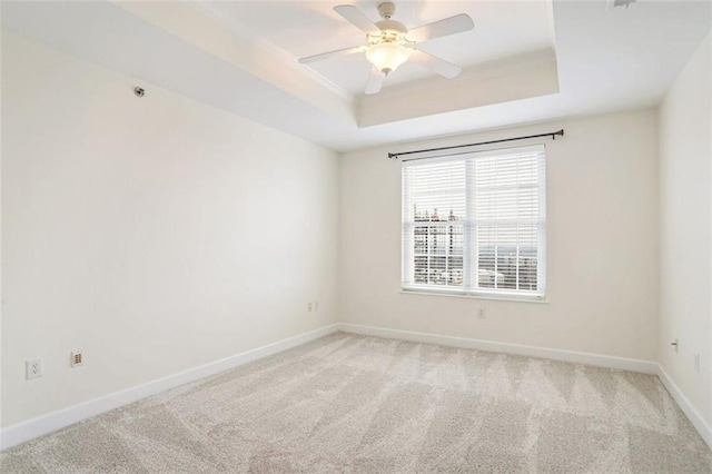 carpeted empty room featuring ceiling fan and a tray ceiling