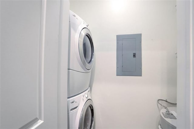 laundry room with stacked washer and dryer and electric panel