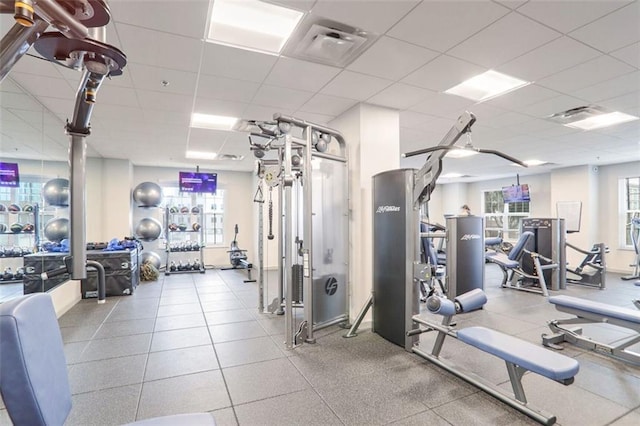 workout area featuring a drop ceiling and plenty of natural light