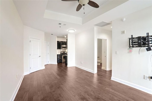 unfurnished living room featuring dark hardwood / wood-style floors, ceiling fan, and a tray ceiling