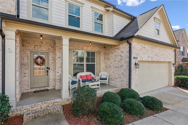 property entrance featuring brick siding, covered porch, and driveway