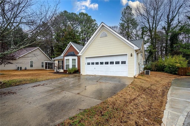 view of front of home with a garage and central AC