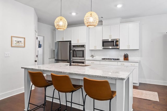 178 Crestbrook Way, Dallas, GA 30157 - kitchen with stainless steel appliances, baseboards, tasteful backsplash, a center island with sink, and a kitchen breakfast bar