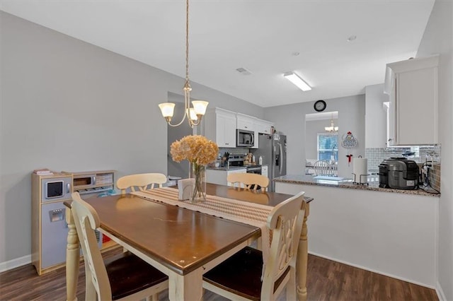 dining room with a notable chandelier and dark hardwood / wood-style flooring