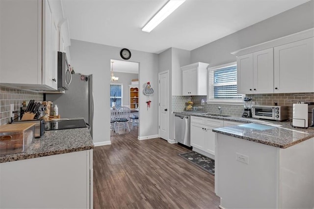 kitchen featuring stone counters, white cabinetry, stainless steel appliances, and dark hardwood / wood-style floors