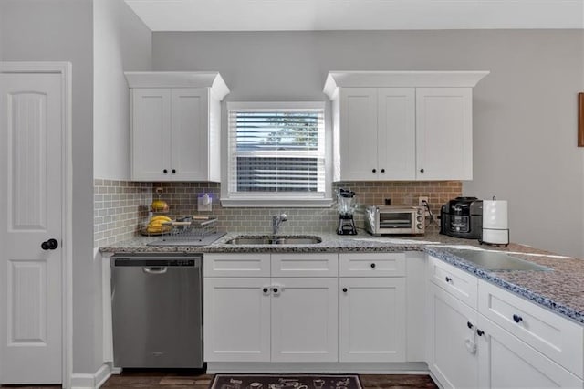 kitchen featuring tasteful backsplash, sink, white cabinets, and stainless steel dishwasher