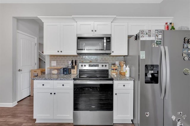 kitchen featuring white cabinetry, light stone countertops, stainless steel appliances, and dark wood-type flooring