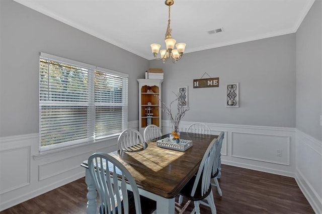 dining area with dark hardwood / wood-style floors, crown molding, and a notable chandelier