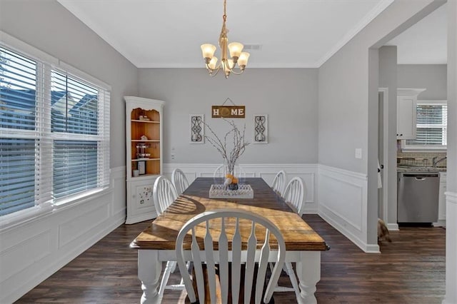 dining area featuring ornamental molding, an inviting chandelier, and dark wood-type flooring