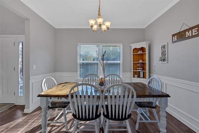 dining space with ornamental molding, dark wood-type flooring, and a notable chandelier