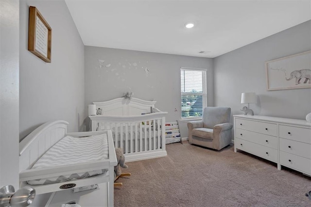 carpeted bedroom featuring a crib