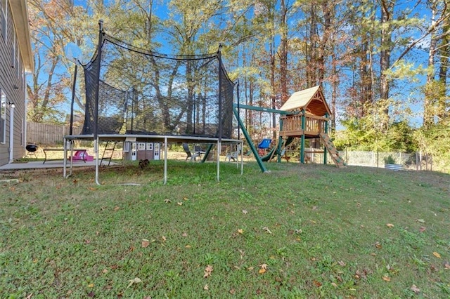 view of yard with a trampoline and a playground