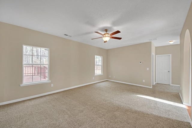 empty room featuring ceiling fan and light carpet