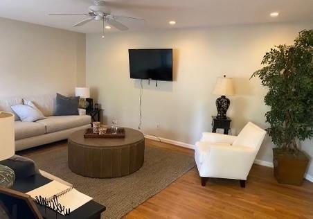 living room featuring hardwood / wood-style flooring and ceiling fan