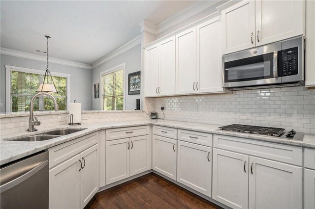 kitchen with light stone counters, sink, white cabinetry, stainless steel appliances, and dark hardwood / wood-style flooring