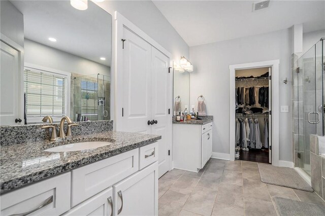 bathroom with vanity, an enclosed shower, and tile patterned floors