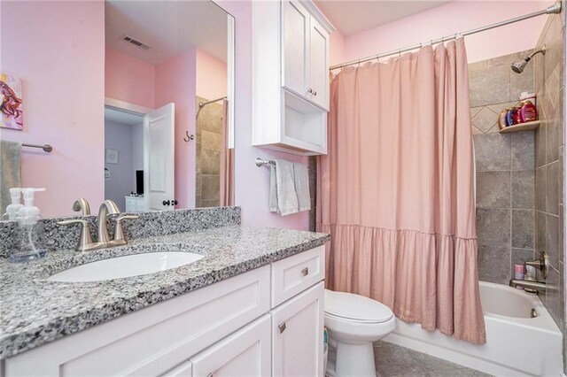 full bathroom with vanity, toilet, shower / bath combo with shower curtain, and tile patterned floors