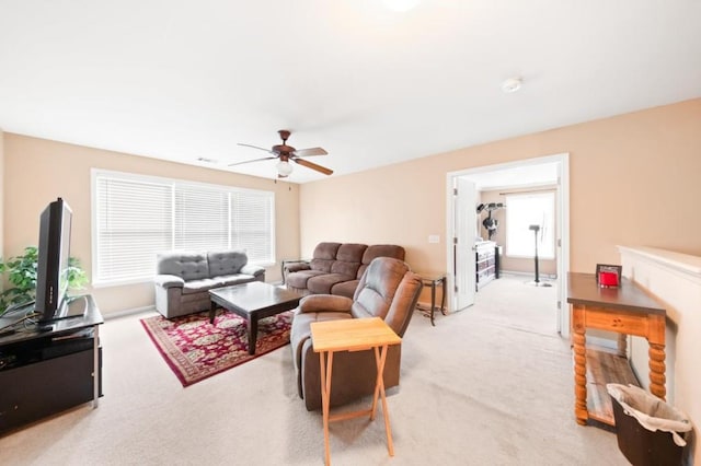 living area featuring light carpet and ceiling fan