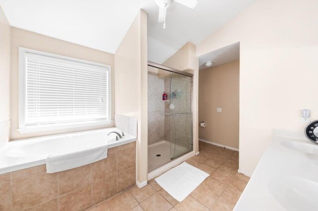 bathroom featuring tile patterned floors, vaulted ceiling, plus walk in shower, and vanity