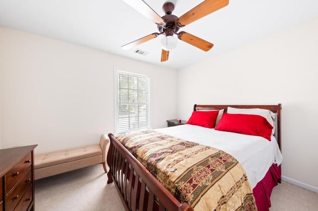 bedroom featuring baseboards, a ceiling fan, visible vents, and light colored carpet