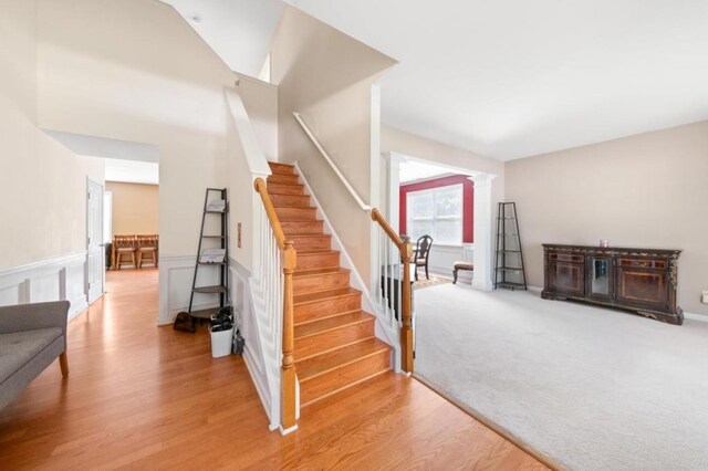 stairway featuring hardwood / wood-style floors and ornate columns