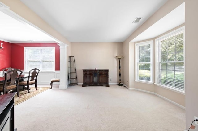 sitting room featuring decorative columns and light carpet