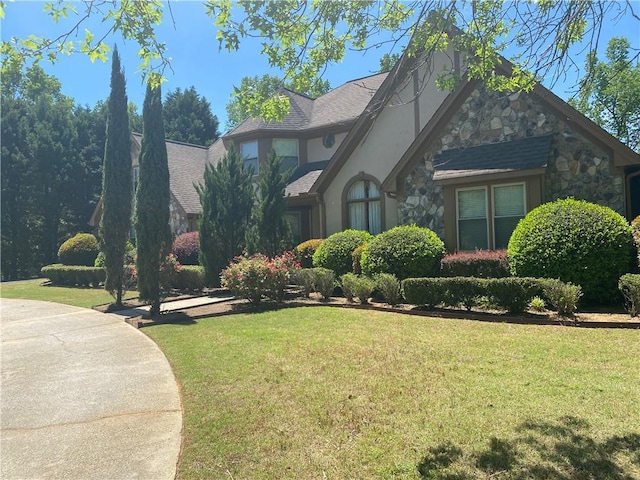 1173 Jimson Cir SE, Conyers, GA 30013 - tudor-style house featuring stone siding, a front yard, and stucco siding