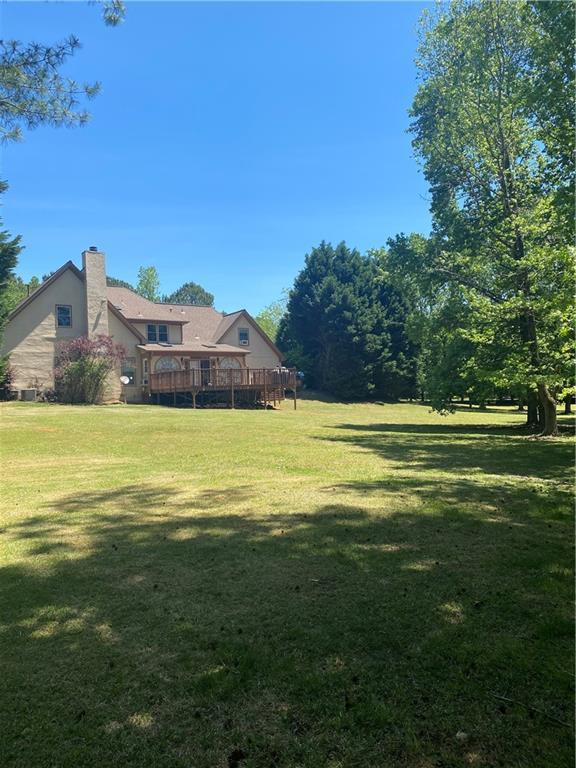1173 Jimson Cir SE, Conyers, GA 30013 - view of green lawn with a wooden deck