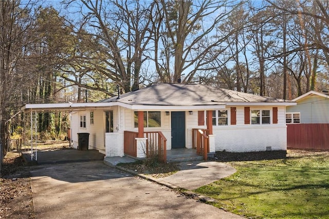 view of front of property with driveway, crawl space, fence, a carport, and brick siding