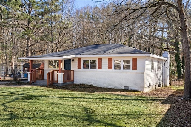 view of front of house featuring brick siding, crawl space, and a front yard