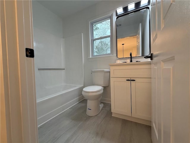 full bathroom featuring toilet, wood-type flooring, shower / washtub combination, and vanity