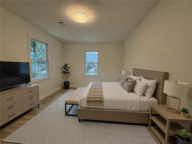 bedroom featuring wood-type flooring and multiple windows