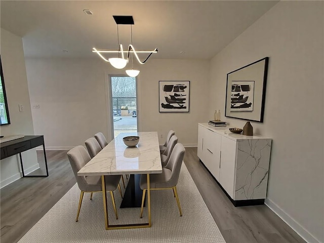 dining area with a chandelier and light hardwood / wood-style floors