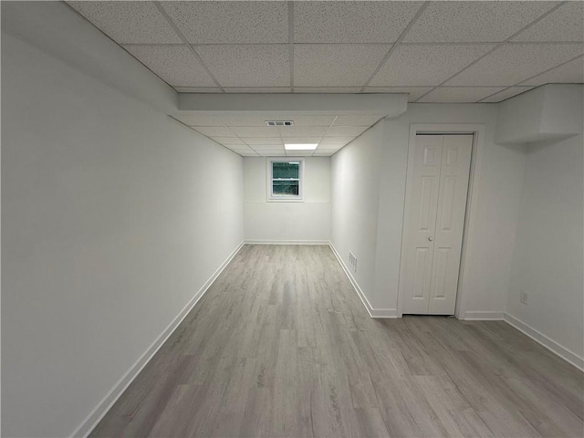 basement featuring light hardwood / wood-style flooring and a drop ceiling